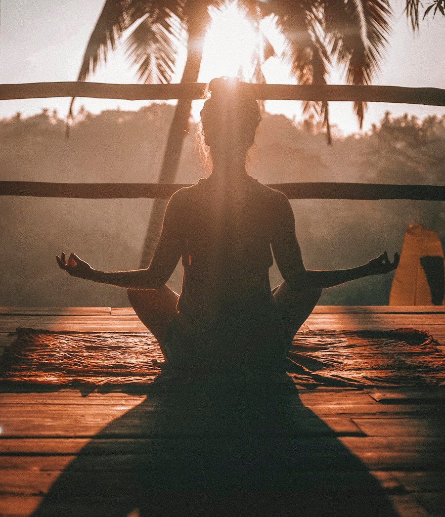 Person meditating at sunset